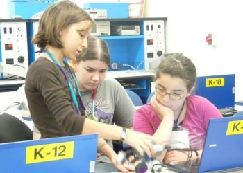 Photo of several female students listening to a teacher.