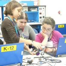 A photo of several girls working in a computer lab