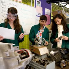 Photo of 2 students looking at designs for engines